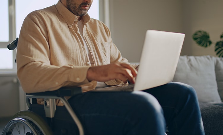 gentleman with in a wheelchair applying for disability on computer